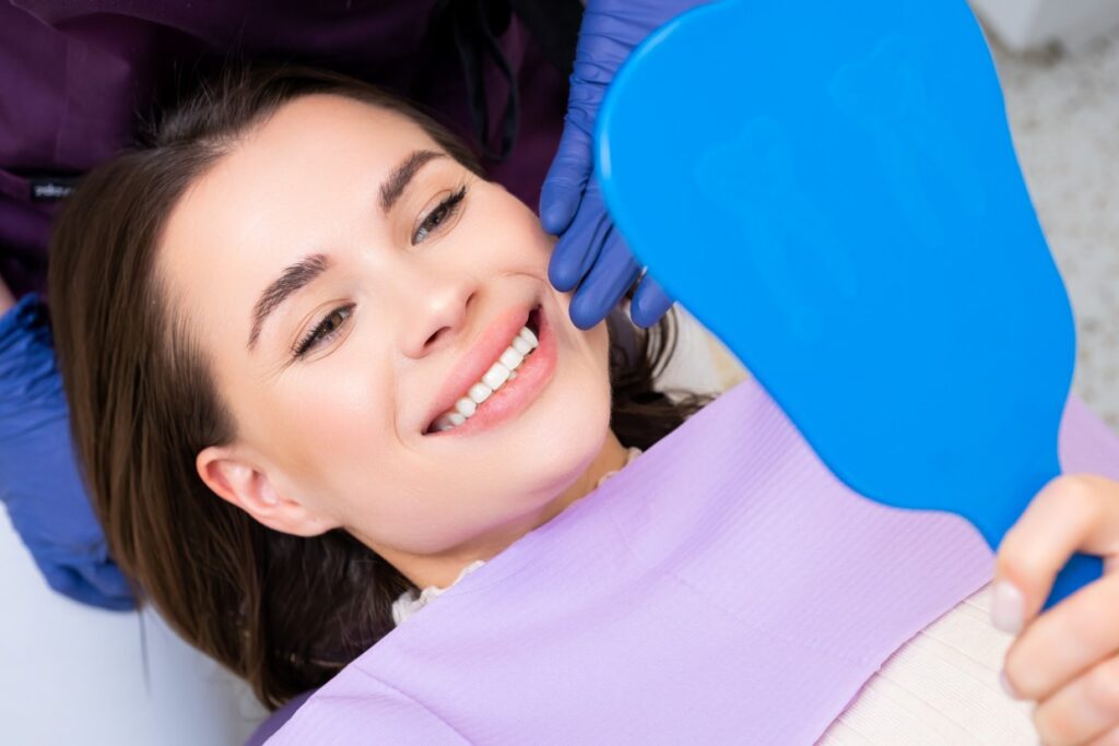 smiling woman patient looks in the mirror