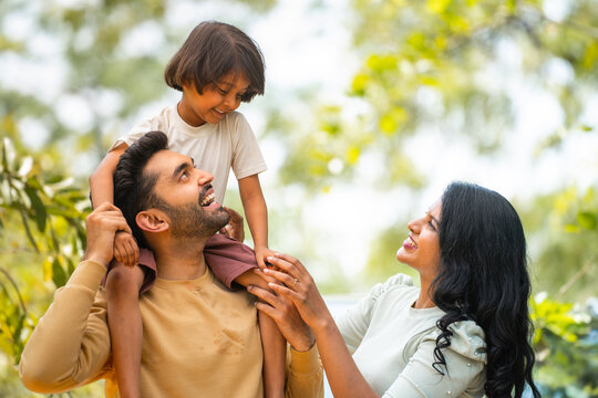 Father, mother and daughter smiling together outdoors